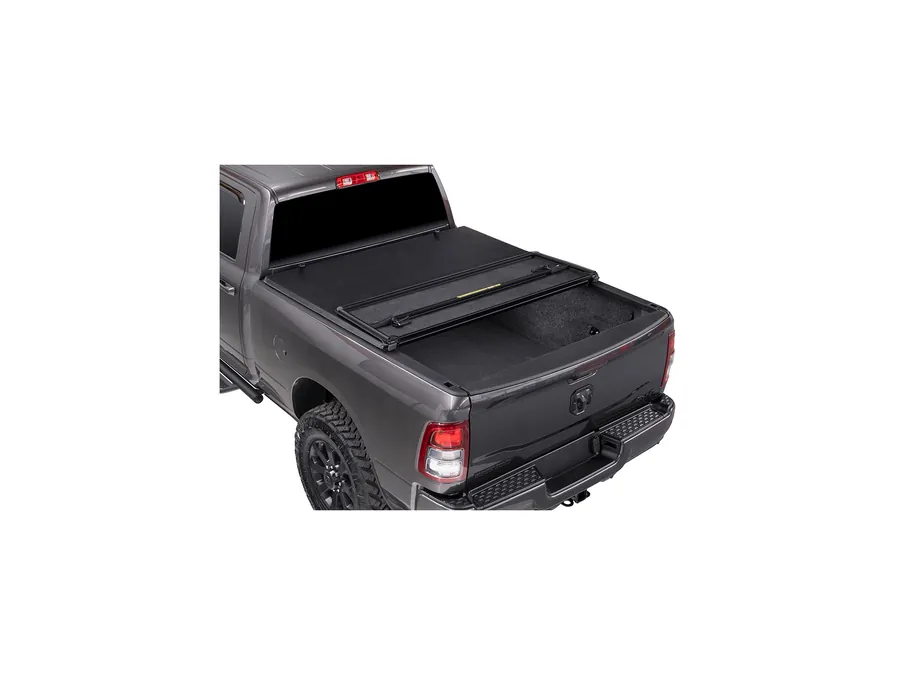 Hard folding bed cover fitted to a grey heavy-duty pickup, rear three-quarter view