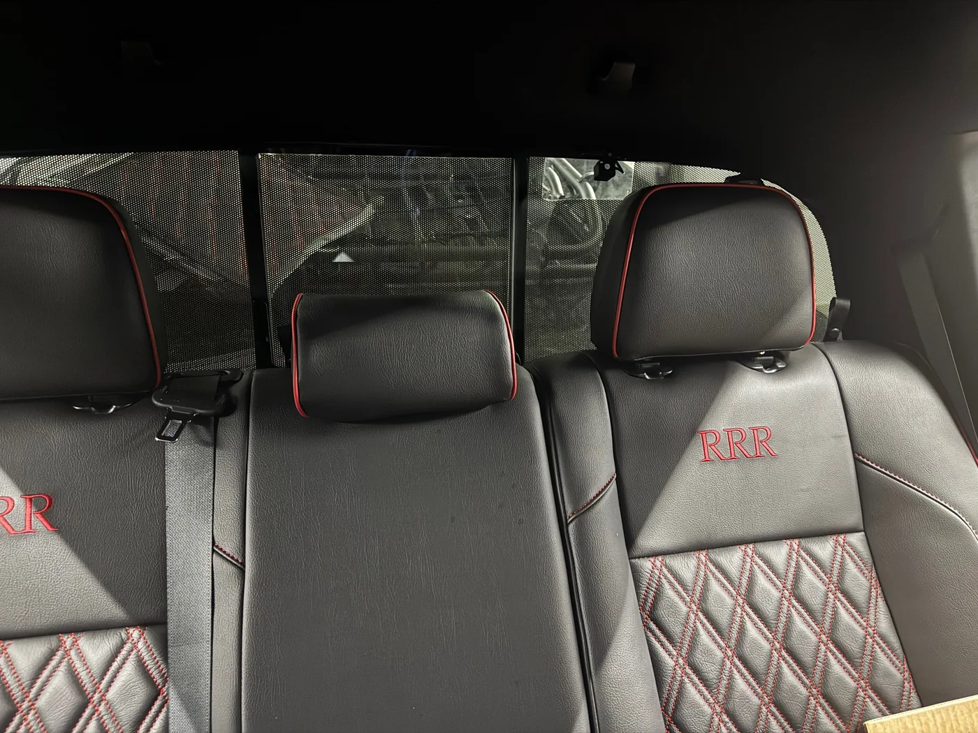 Rear-seat and deck area of a 2023 Toyota Tacoma before the custom speaker pod build